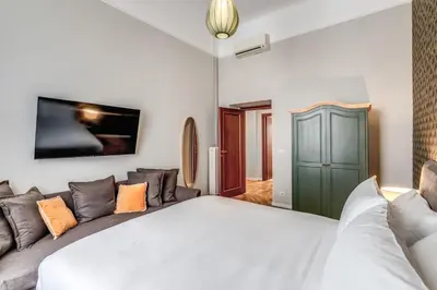 a bedroom with a white bed and a couch at DOWNTOWN SRL - The Great Court and The Great Chill in Rome