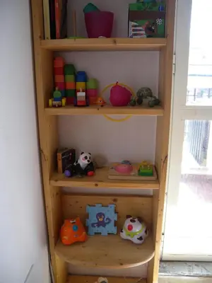 a wooden book shelf with toys on it at Esquilino Piano Alto in Rome