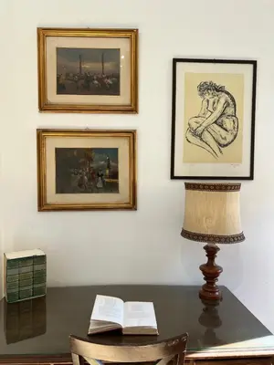 a table with a lamp and paintings on a wall at Feel at home in Rome
