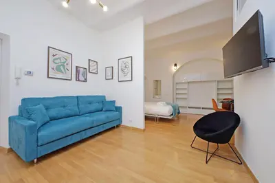 a living room with a blue couch and a tv at Modern flat in Termini Station in Rome