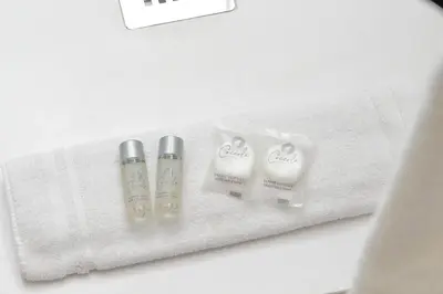 two bottles of moisturizers sitting on a white towel at Modern flat in Termini Station in Rome