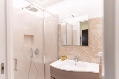 a bathroom with a white sink and a shower at Casa Arco Roma in Rome
