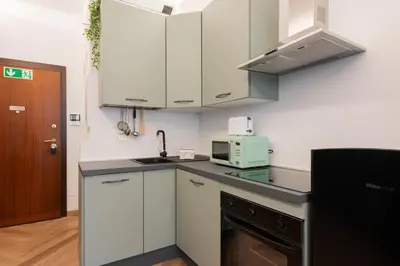 a kitchen with white cabinets and a sink and a microwave at Casa Vacanze Ourplaces Sacchetti in Rome