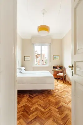 a bedroom with a white bed and a wooden floor at Casa Augusta, a Burghesius home in Rome