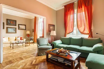 a living room with green couches and a coffee table at Casa Augusta, a Burghesius home in Rome