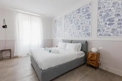 a bedroom with a bed with blue and white wallpaper at Loft Piazza Vittorio - Zen 38 in Rome