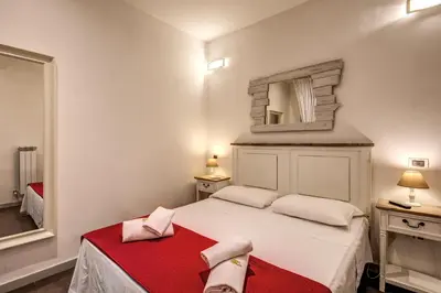 a bedroom with a white bed and a mirror at GuestHouse o Affittacamere La civetta di Trastevere in Rome