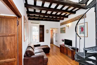 a living room with a couch and a tv at Trastevere Penthouse amazing terrace in Rome