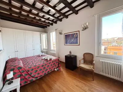 a bedroom with a bed and a chair and a window at Trastevere Penthouse amazing terrace in Rome