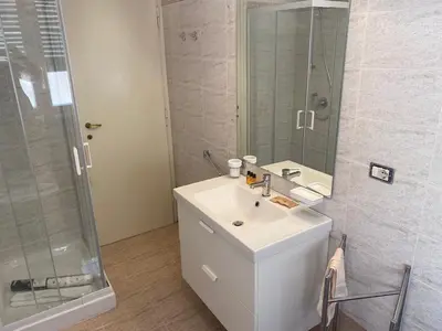 a white bathroom with a sink and a shower at Clodio Apartment in Rome