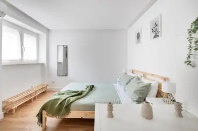 a white bedroom with a bed and a table at NOH Vatican Studio in Rome