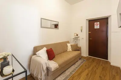 a living room with a couch and a brown door at Vaticano Domvs - Appartamento ai Musei Vaticani in Rome