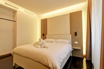 a bedroom with a white bed with white sheets at SirtHouse in Rome