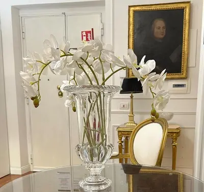 a glass vase with white flowers on a glass table at Alloggio turistico King Plaza in Rome