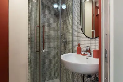 a bathroom with a sink and a shower with a mirror at GuestHost - Aurea Domus Comfort suite in centro a Roma in Rome
