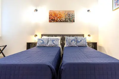 two beds sitting next to each other in a bedroom at Mami Apartment in Rome