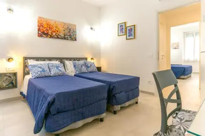 a bedroom with two beds with blue comforters at Mami Apartment in Rome