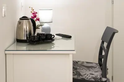 a table with a tea kettle and a remote control on it at Mami Apartment in Rome