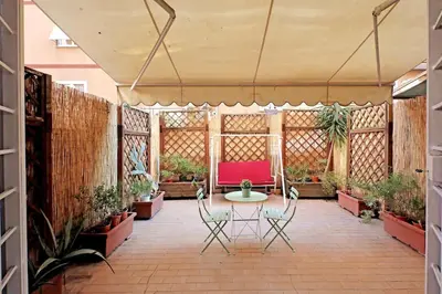 a patio with a table and chairs and plants at La Dolce Vita - Vatican Studio with Large Terrace in Rome