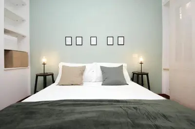 a bedroom with a large white bed with two lamps at La Dolce Vita - Vatican Studio with Large Terrace in Rome