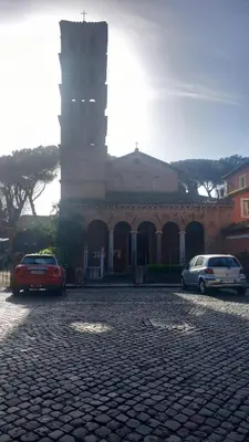 two cars parked in front of a building with a clock tower at Il regno dei colori in Rome