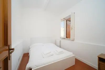 a white room with a bed and a window at Juan&Elisa Trevi by BuddyRent in Rome