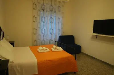 a bedroom with a bed and a chair and a television at Casa Giovanna in Rome