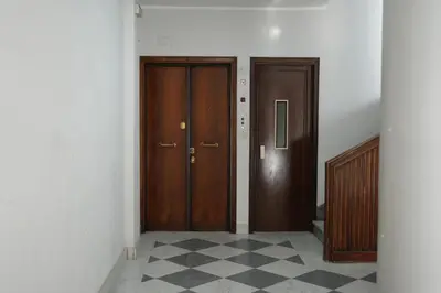a hallway with two wooden doors and a checkered floor at Casa Giovanna in Rome