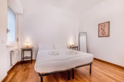 a large white bed in a room with two lamps at Zampieri Loft in Rome