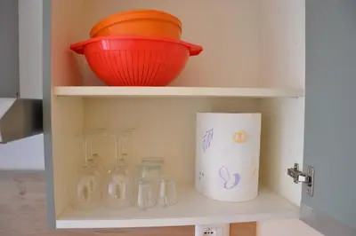 an open cabinet with glass bottles and an orange bowl at Il Rifugio dell Inventore in Rome