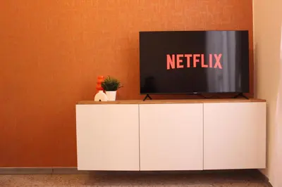 a tv on top of a white cabinet at Tiberim, Centro Storico in Rome