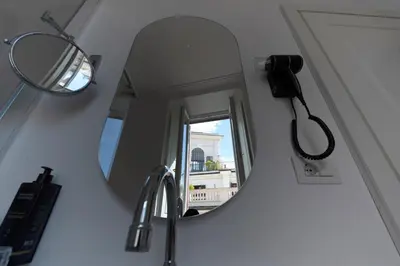a mirror in a bathroom with a hair dryer and a sink at AGH Babuino in Rome