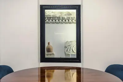 a table with a mirror and a vase at Vatican Home in Rome