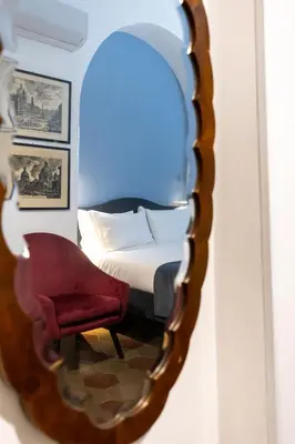 a bedroom with a bed and a chair in a mirror at Vatican Home in Rome