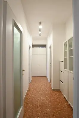 an empty corridor with white walls and a hallway with white doors at Vatican Firefly House in Rome