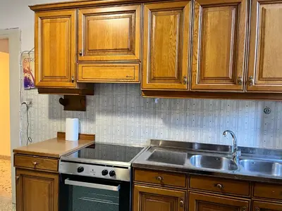 a kitchen with wooden cabinets and a sink at appartamento elegante Roma - Vicino alla metro in Rome
