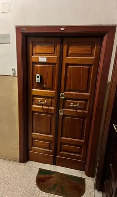 a pair of wooden doors in a room with a rug at appartamento elegante Roma - Vicino alla metro in Rome