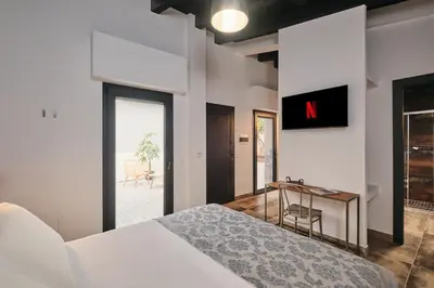 a bedroom with a bed and a table and a desk at Le Arcate, suite 1 Lavinia, suite 2 Lucilla in Rome