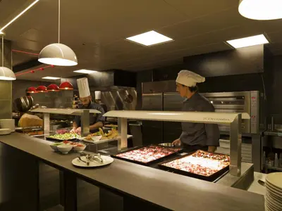 two chefs preparing food in a restaurant kitchen at A.Roma Lifestyle Hotel in Rome