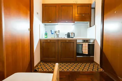 a small kitchen with wooden cabinets and a sink at Stylish Studio in Sallustiano in Rome