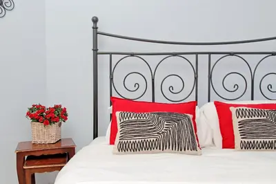 a bedroom with a bed with red and black pillows at 6 People Apartment at Vatican in Rome