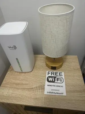 a free wifi sign on a wooden table with a lamp at Alloggio Fiorella in Rome