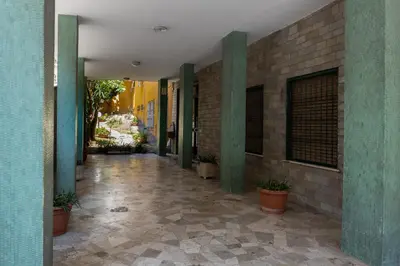 a hallway of a building with green pillars and plants at Be Max Guest House in Rome