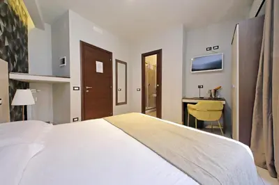 a bedroom with a large white bed and a desk at Roma Suite Centro in Rome