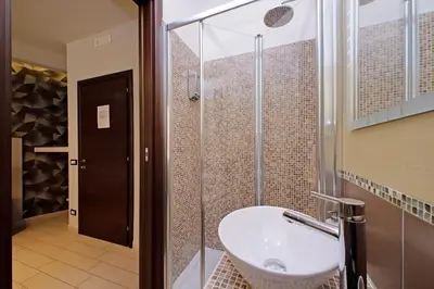 a bathroom with a sink and a glass shower at Roma Suite Centro in Rome