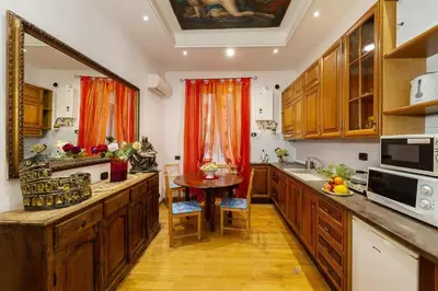 a kitchen with wooden cabinets and a table in it at Sancta Scala in Rome