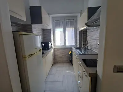 a kitchen with a white refrigerator and a window at Alessia C Locazione turistica in Rome