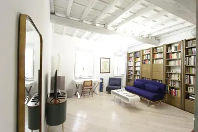 a living room with a blue couch and book shelves at Grotte Apartment in Rome