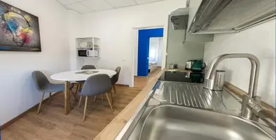 a kitchen with a sink and a table with chairs at JHHIT - Panoramic Modern Penthouse in Rome