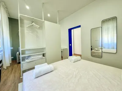 a bedroom with a large white bed and a mirror at JHHIT - Panoramic Modern Penthouse in Rome